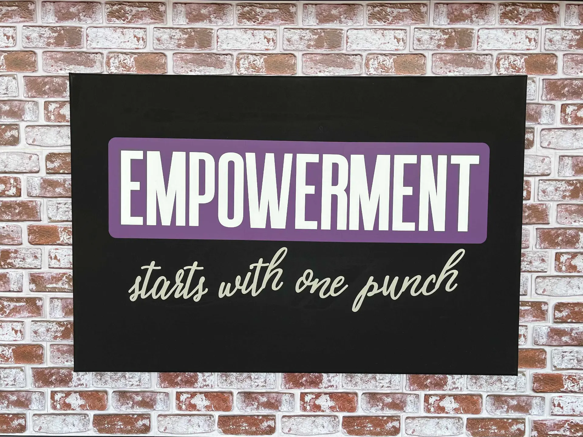 "Empowerment starts with one punch" wall sign inside EMPOWERED Fitness Studio, a cardio kickboxing gym in Evansville, IN